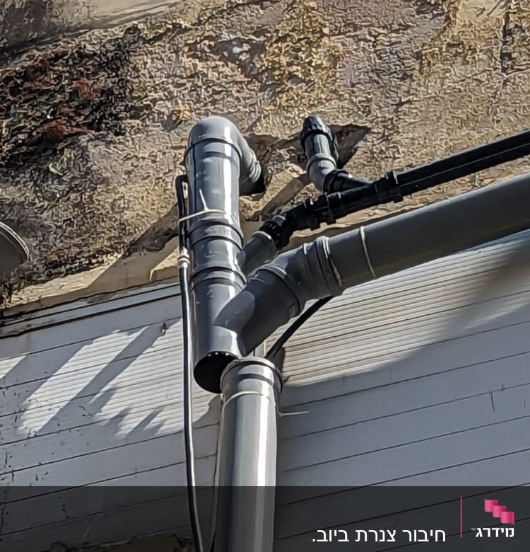 צינורות מתכת מחוברים לקיר חיצוני